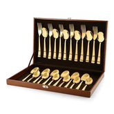 Gold-colored cutlery set with forks, spoons, baby spoons and tea spoons neatly arranged in a brown case.